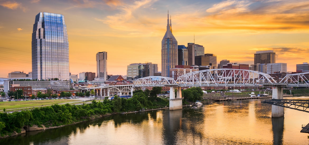 nashville, tennessee, nashville skyline across the river at sunset with bridge