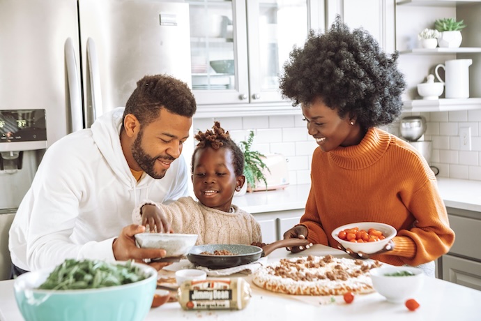 Family making homemade pizza together for National Pizza Day