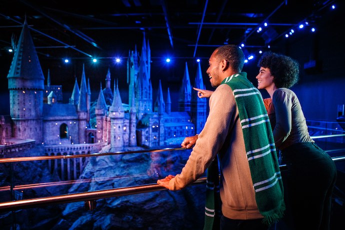 a couple enjoy the models at Harry Potter exhibit