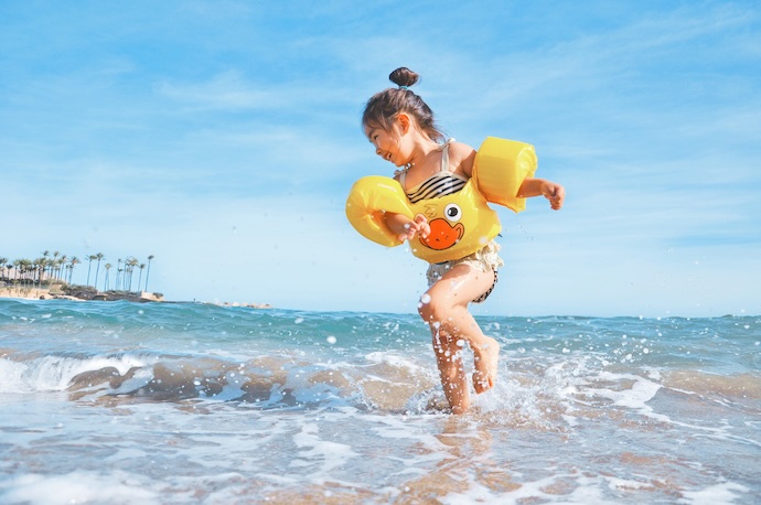 little girl paddling on beach