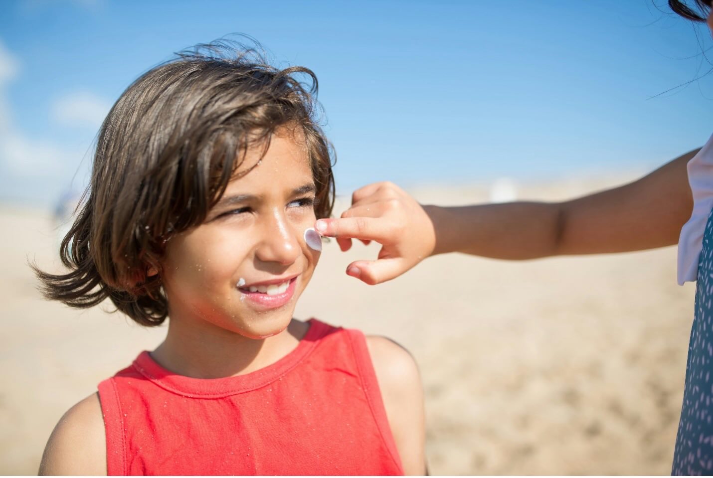 A child getting suncream on face