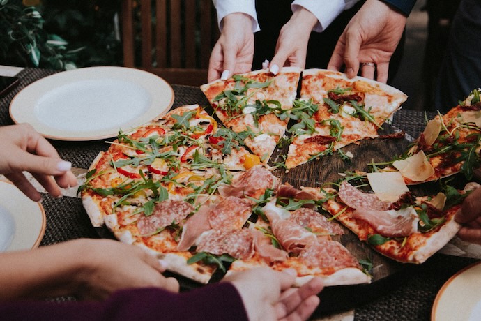 family share slices of pizza